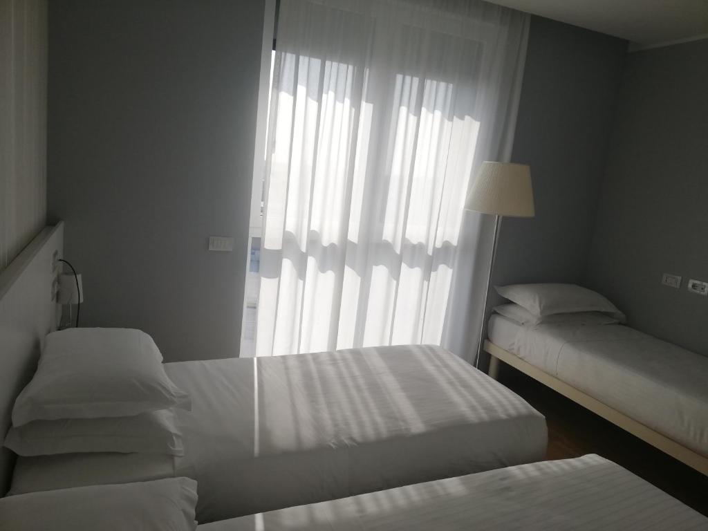 Łóżko lub łóżka w pokoju w obiekcie Novo Hotel Rossi