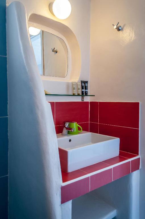 a bathroom with a white sink and a mirror at Paleochori Studios in Paliochori