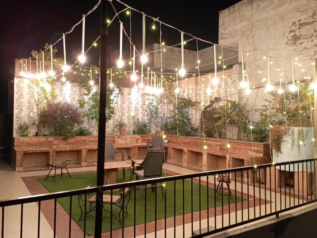 a patio with lights and a table and chairs at The Hideout Agra - Boutique Homestay near Taj in Agra
