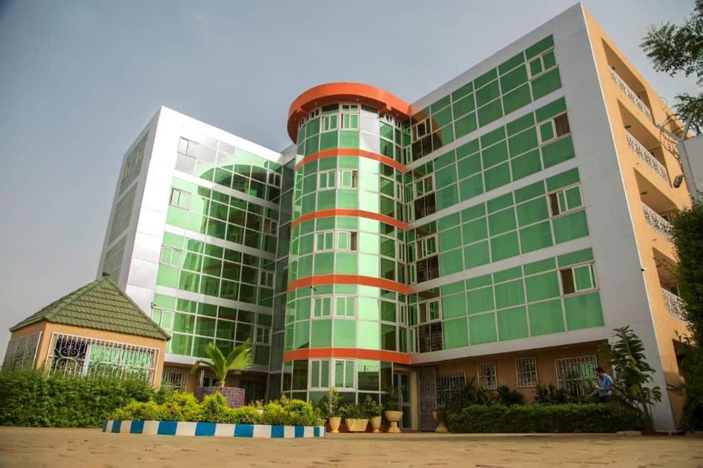 a large green building with a red at Hotel Univers 3 Aeroport Luxe in Niamey