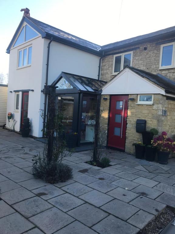 uma casa com uma porta vermelha e um pátio de pedra em Silverstone Bed and Breakfast em Silverstone