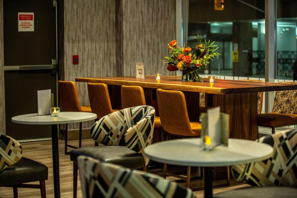 a restaurant with tables and chairs with a vase of flowers at Holiday Inn Toronto Downtown Centre by IHG in Toronto