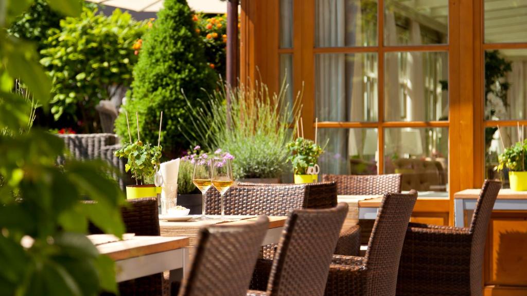 a table with chairs and wine glasses on a patio at Superior Hotel Tirolerhof - Zell am See in Zell am See