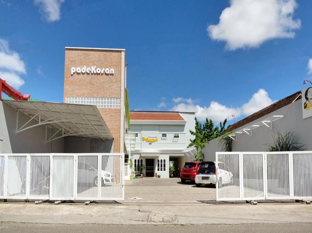 a building with a white gate in front of a parking lot at Super OYO 90730 Padekosan in Tulungagung