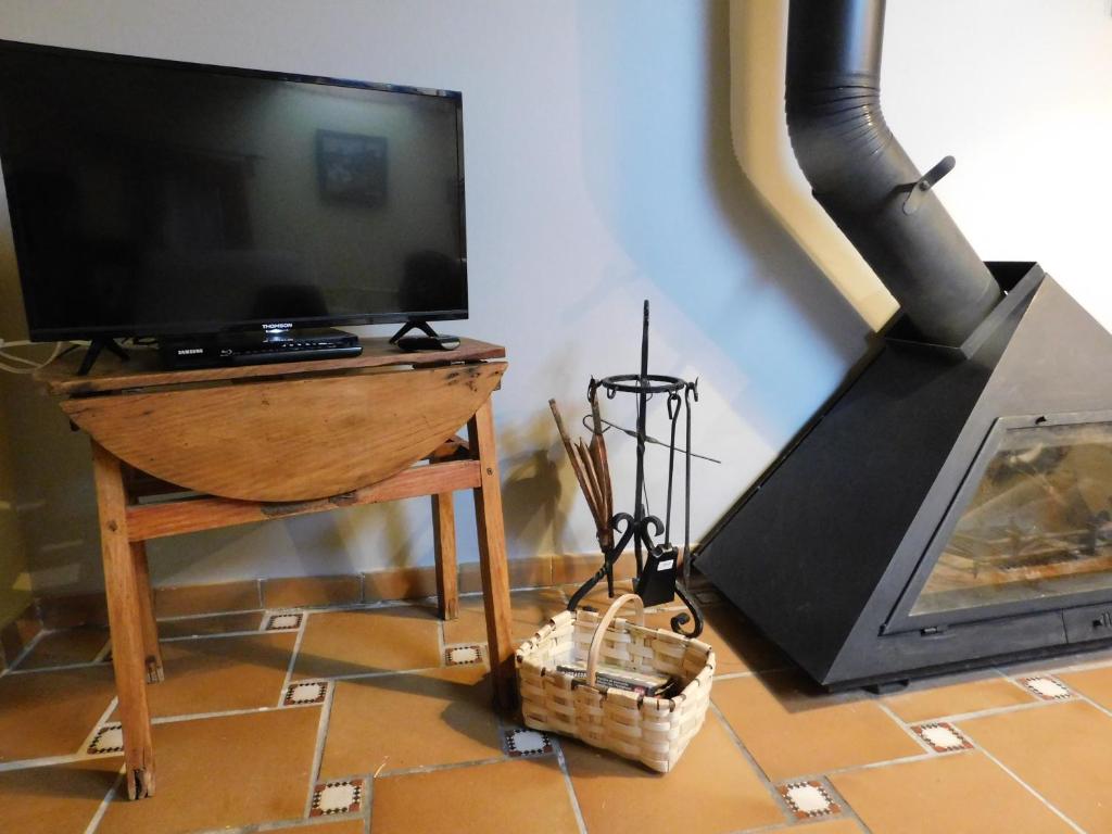 a television sitting on a table next to a fireplace at La Silla de la Reina in Navarredonda de Gredos