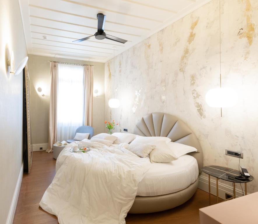 a white bedroom with a large white bed in a room at Castellano Hotel & Suites in Nafplio