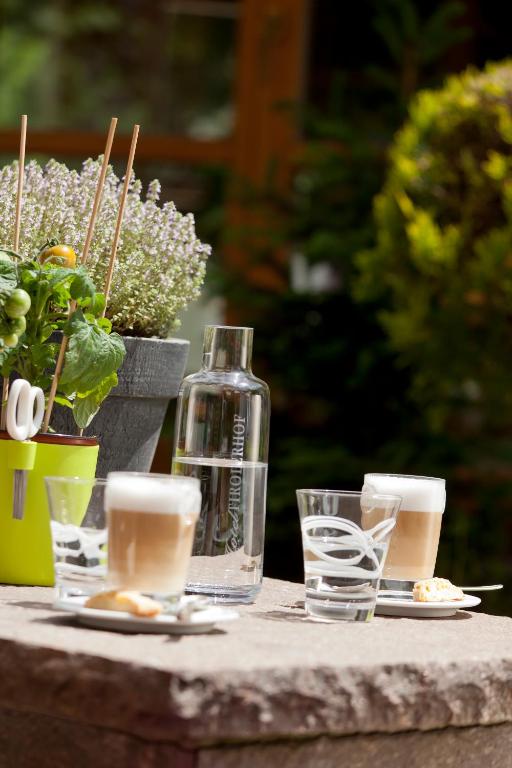 a table with glasses and a bottle of water on it at Superior Hotel Tirolerhof - Zell am See in Zell am See