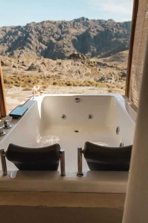 a bath tub with a view of the desert at CASAS VIEJAS LODGE in La Cumbrecita