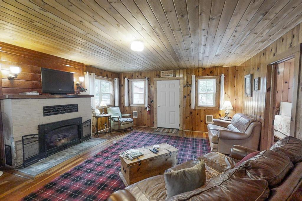 a living room with a couch and a fireplace at River's Edge Cabin in Joseph