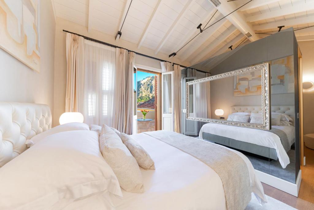 a bedroom with two beds and a large window at Castellano Hotel & Suites in Nafplio