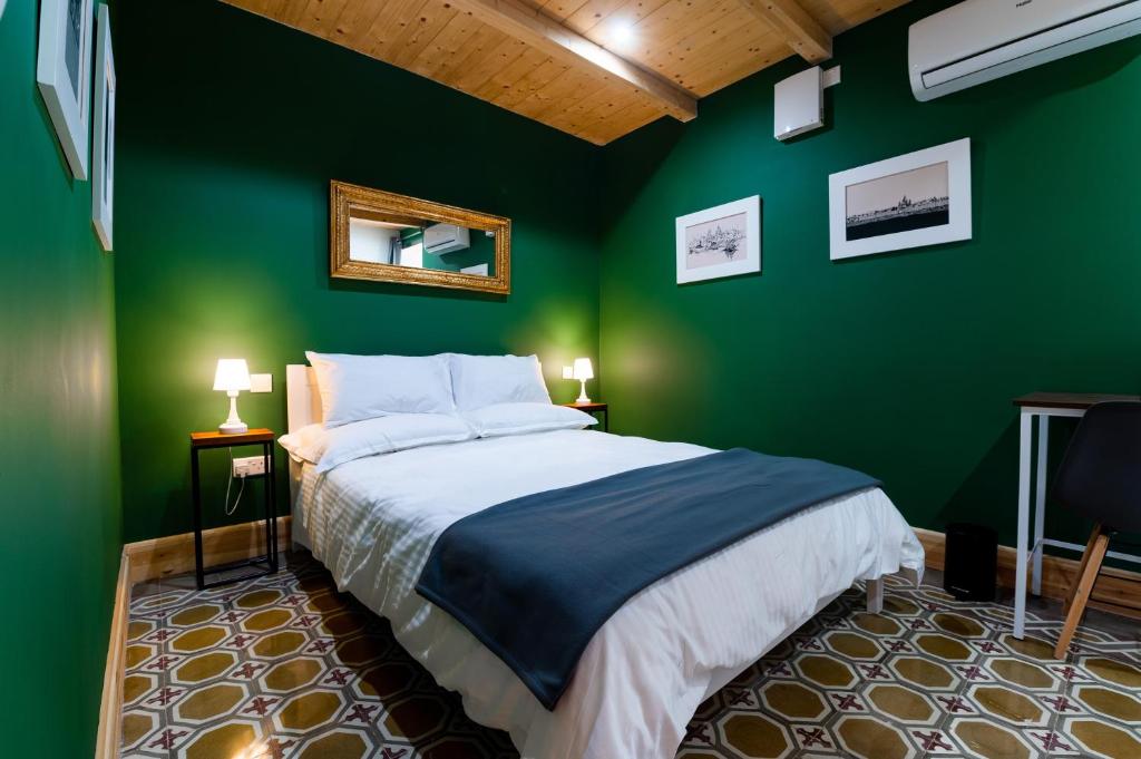 a green bedroom with a bed and a green wall at Monreal Boutique Townhouse - R024RM5 in Paola