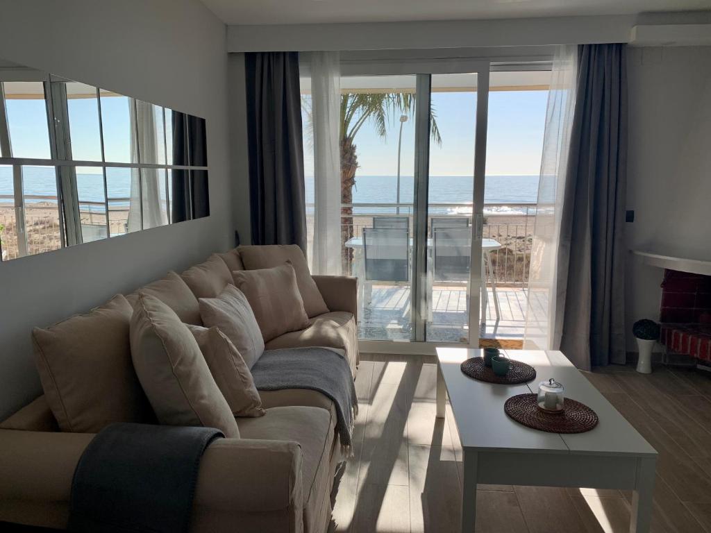 sala de estar con sofá y vistas al océano en Formentor en Castelldefels