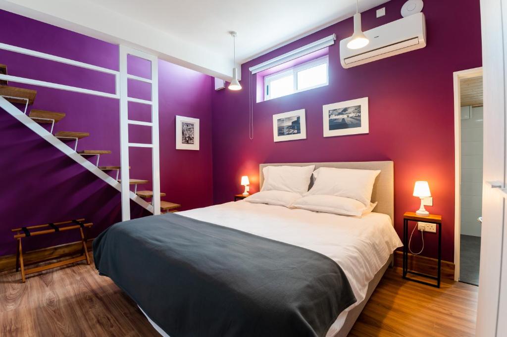 1 dormitorio con cama y pared púrpura en Monreal Boutique Townhouse - R024RM6 en Paola