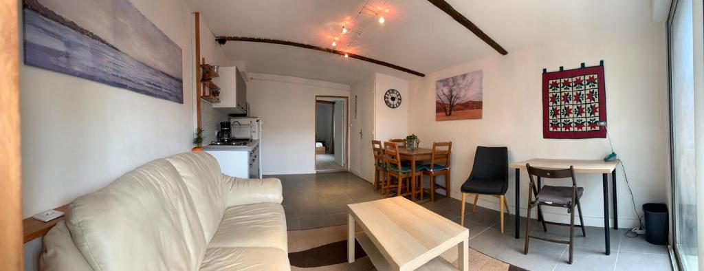 sala de estar con sofá y mesa en Ravissante suite avec parking sur place. en Pessac