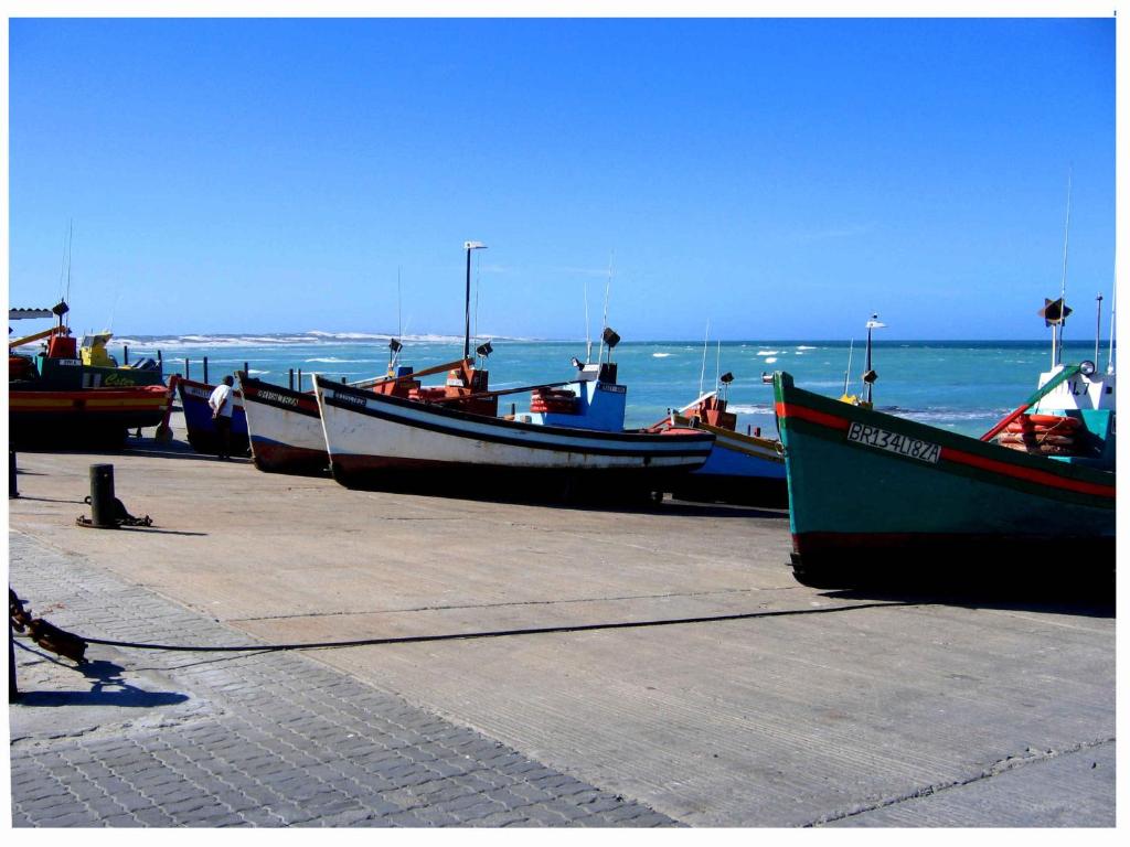 a group of boats parked on a pier near the ocean at Karoo Huis in Arniston