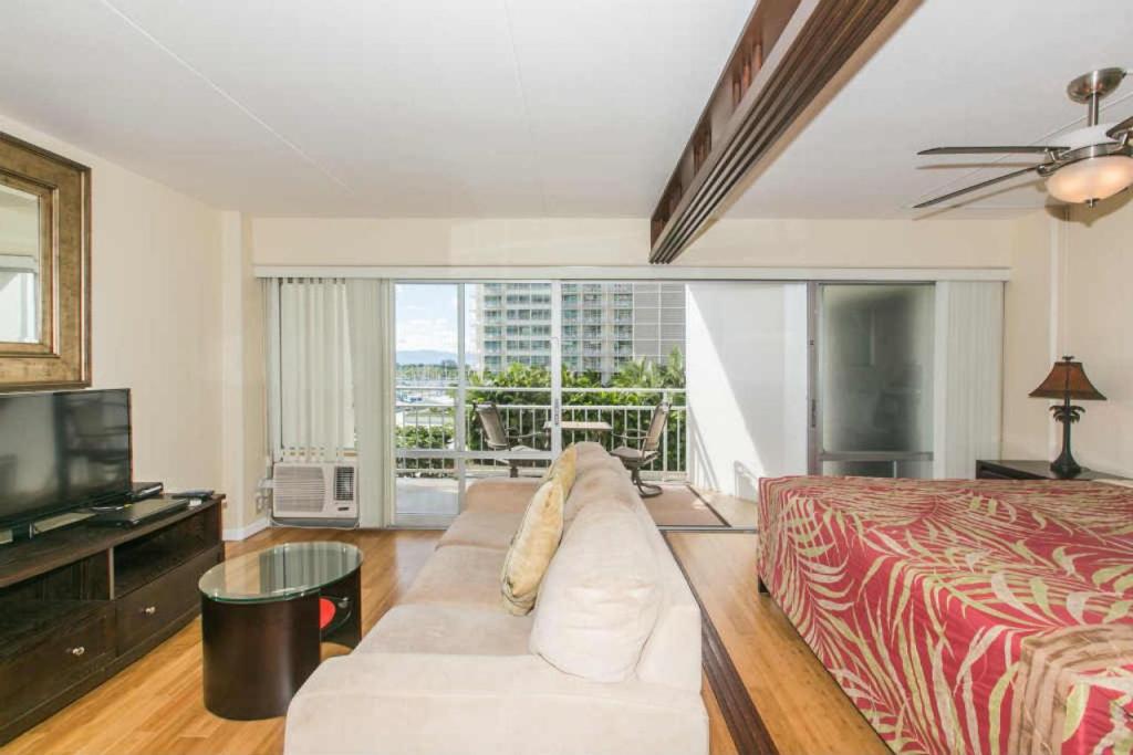 a living room with a couch and a bed and a television at Ilikai Tower 527 Yacht Harbor View 1BR in Honolulu
