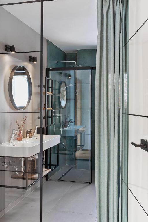 bagno con lavandino e doccia in vetro di Holzhackerin - the charming Haus am Berg a Schladming