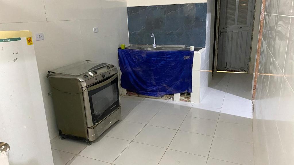 une petite cuisine avec une cuisinière et un évier dans l'établissement Blue House, à Baía Formosa
