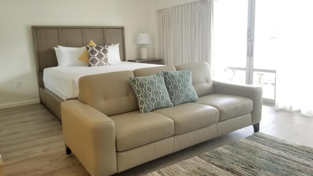 ein Wohnzimmer mit einem Sofa und einem Bett in der Unterkunft Ilikai Tower 1717 City View 1BR in Honolulu