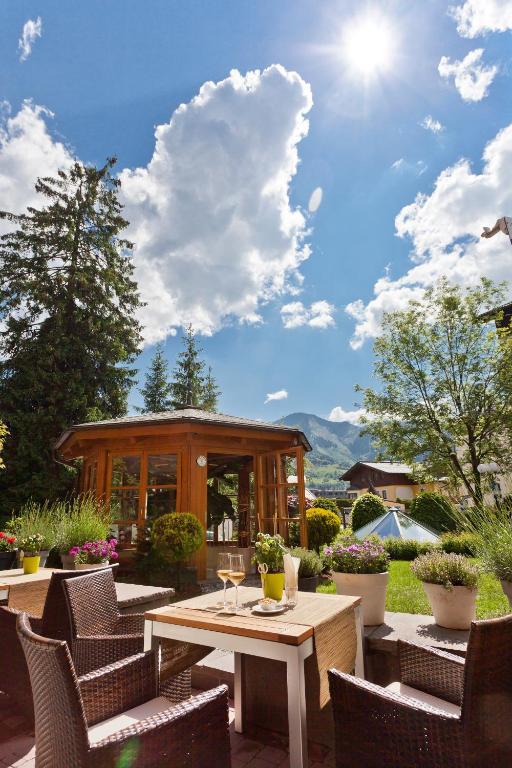a patio with a table and chairs and a building at Superior Hotel Tirolerhof - Zell am See in Zell am See