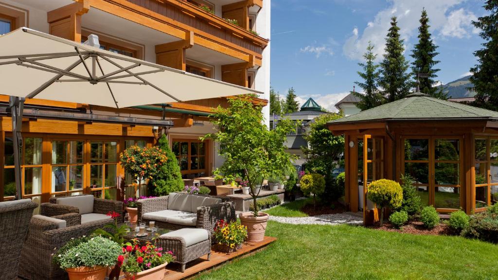 a patio with an umbrella and a gazebo at Superior Hotel Tirolerhof - Zell am See in Zell am See