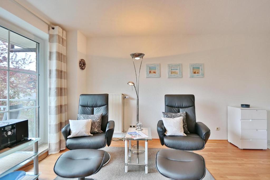 2 sillas y una mesa en la sala de estar en Seesternresidenz Seesternresidenz Appartement 8 en Scharbeutz
