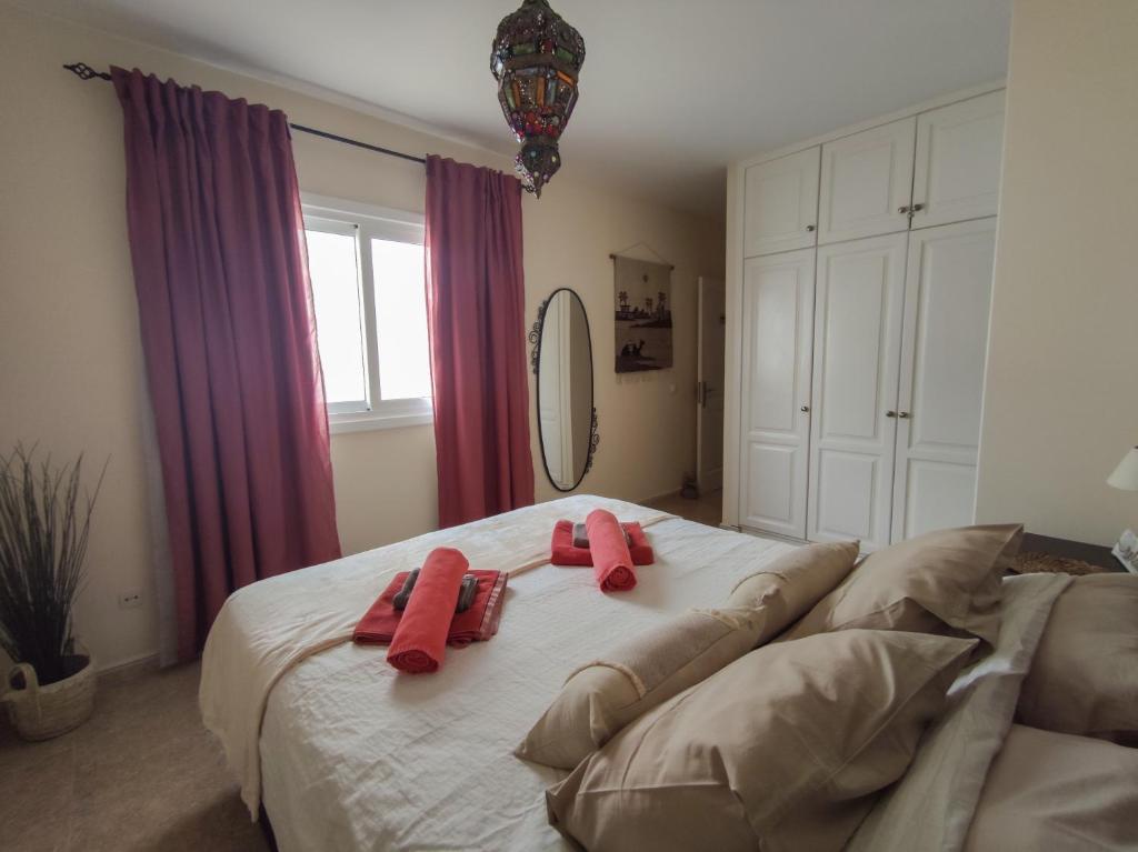 a bedroom with a large bed with red towels on it at Casa Chinijo in Famara