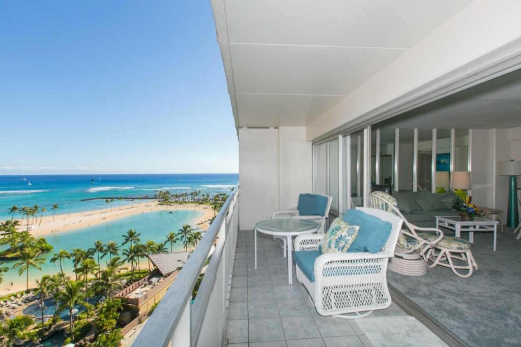 - un balcon avec des chaises et une table donnant sur l'océan dans l'établissement Ilikai Tower 1240 Lagoon View 1BR, à Honolulu