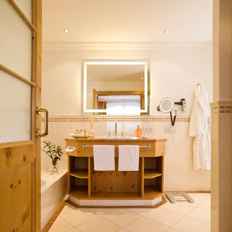 a bathroom with a sink and a mirror at Superior Hotel Tirolerhof - Zell am See in Zell am See