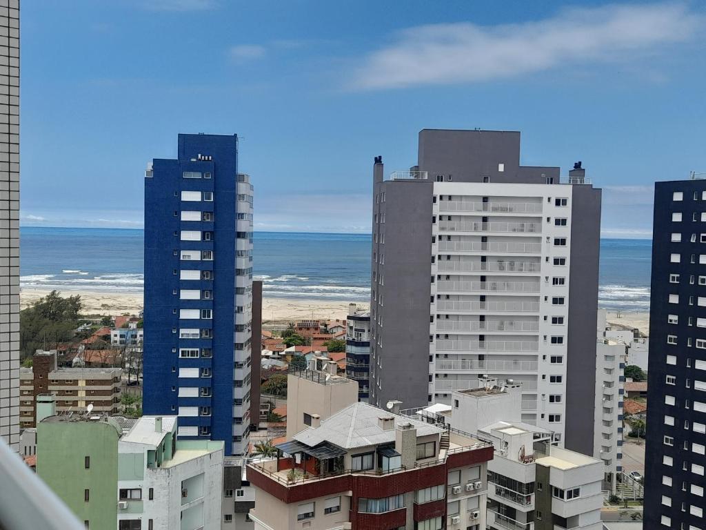 un perfil urbano con edificios altos y el océano en Apartamento com Vista Oceânica, en Torres