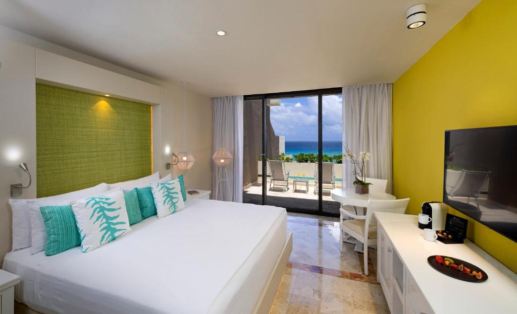 a bedroom with a large white bed and a television at Paradisus Cancun All Inclusive in Cancún