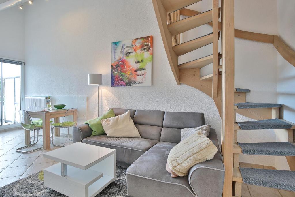 a living room with a couch and a staircase at Residenz Ostseestrand Appartement 26 in Scharbeutz