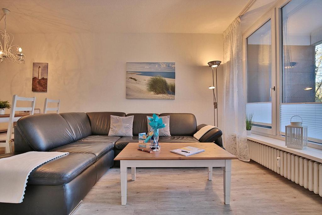 ein Wohnzimmer mit einem Ledersofa und einem Couchtisch in der Unterkunft Strandresidenz Timmendorfer Strand Strandresidenz Appartement 108 in Timmendorfer Strand