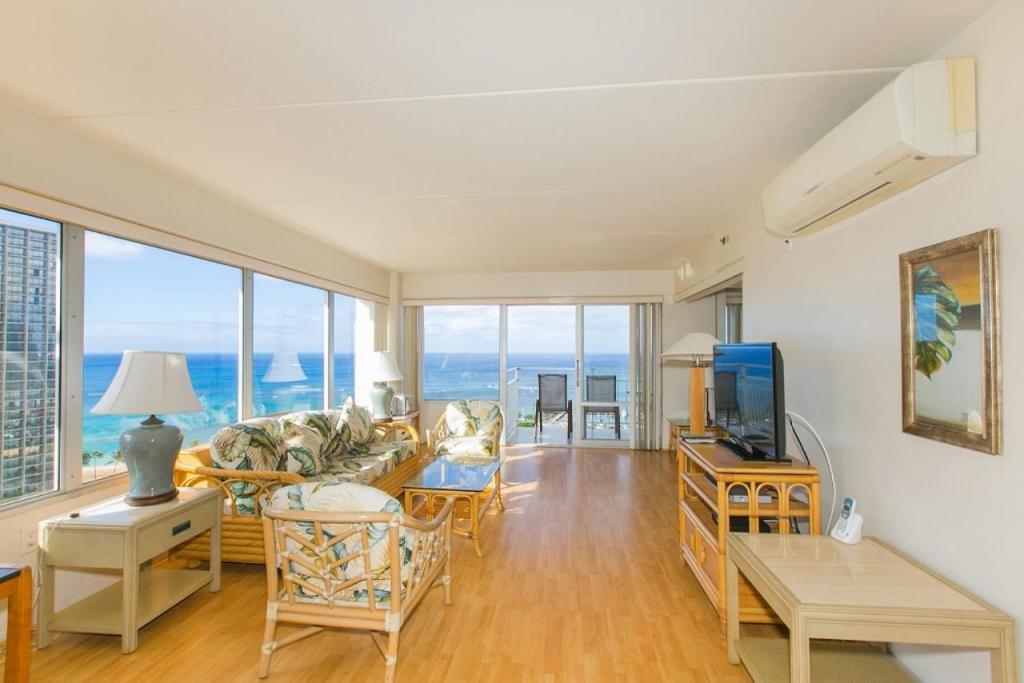 uma sala de estar com um sofá e uma televisão em Ilikai Tower 1744 Yacht Harbor View 2BR em Honolulu