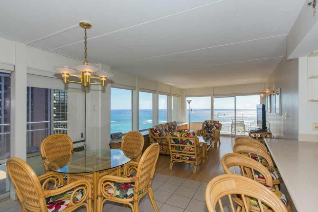 ein Esszimmer mit einem Tisch, Stühlen und Meerblick in der Unterkunft Ilikai Tower 1844 Yacht Harbor View 2BR in Honolulu