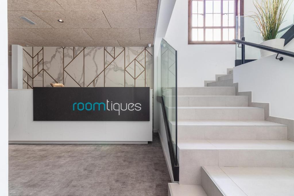 a lobby with stairs and a sign that reads coronitals at Flatguest RoomTiques Private Rooms in Las Palmas de Gran Canaria