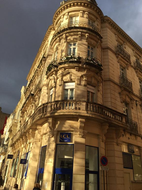 un edificio alto con balcón en la parte superior en Appart République en Narbonne