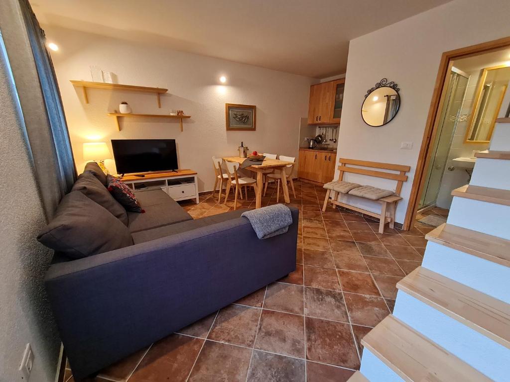 a living room with a blue couch and a table at Sweet House and Apartment in Rovinj