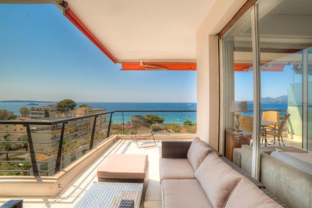 カンヌにあるIMMOGROOM- 2 bedrooms -Panoramic Sea view - Huge Terrace - Beachのリビングルーム(ソファ付)が備わり、海の景色を望めます。