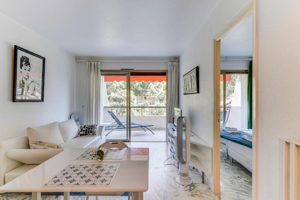 ein Wohnzimmer mit einem Sofa und einem Tisch in der Unterkunft IMMOGROOM- Open view terrace - Parking - Next CROISETTE in Cannes