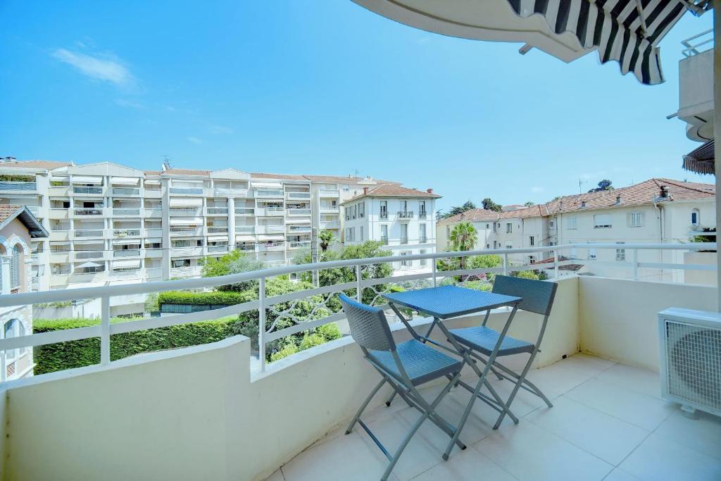 balkon z 2 krzesłami i stołem na nim w obiekcie IMMOGROOM - Terrace - 2 bedrooms - Downtown - Air conditioning - Wifi w Cannes