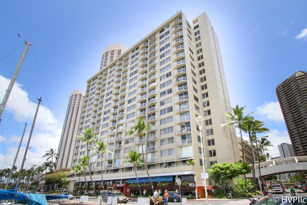 een groot gebouw met palmbomen ervoor bij Ilikai Marina 987 City View Studio in Honolulu