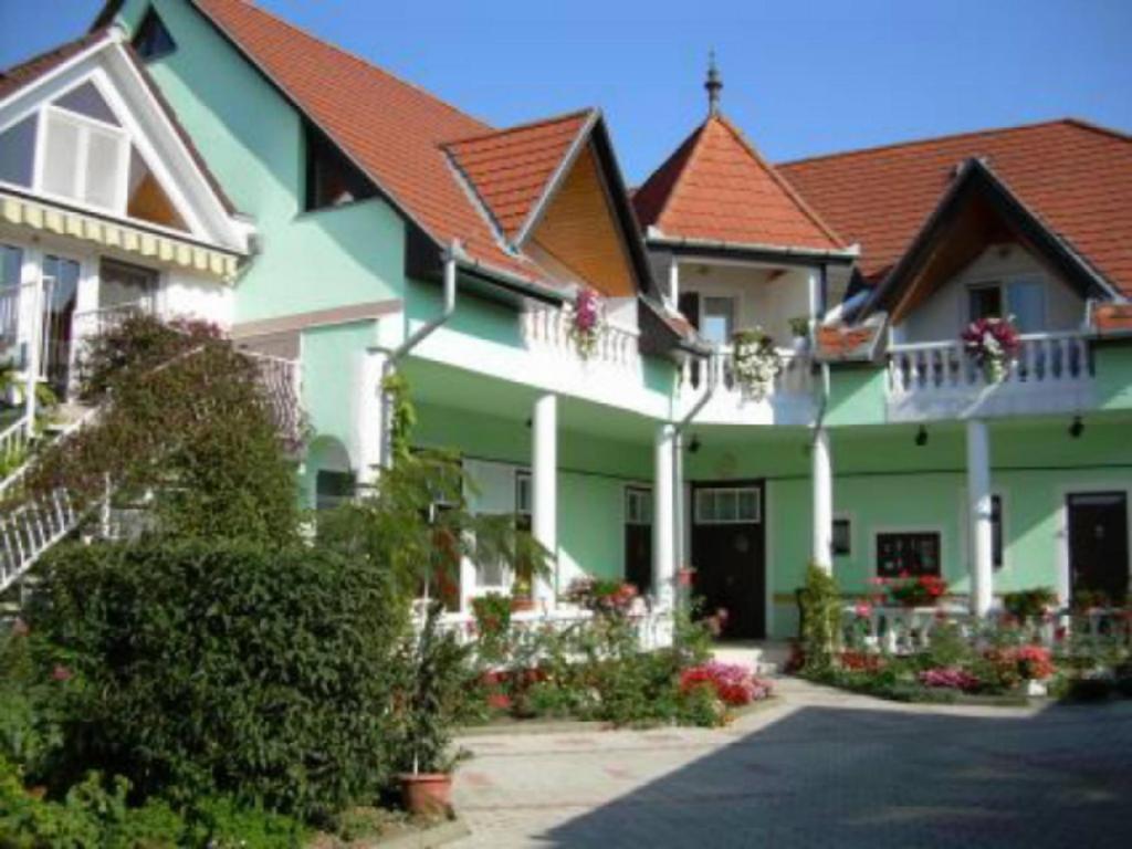 a large green building with flowers in front of it at Haus Kati in Hévíz