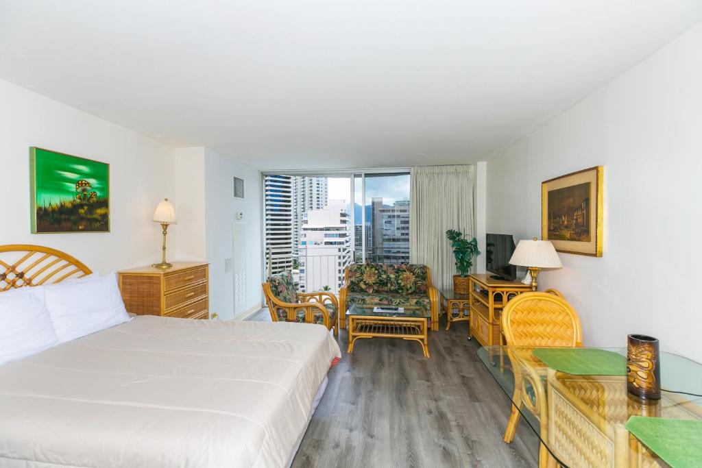 Habitación de hotel con cama, mesa y sillas en Ilikai Marina 1495 City View Studio en Honolulu
