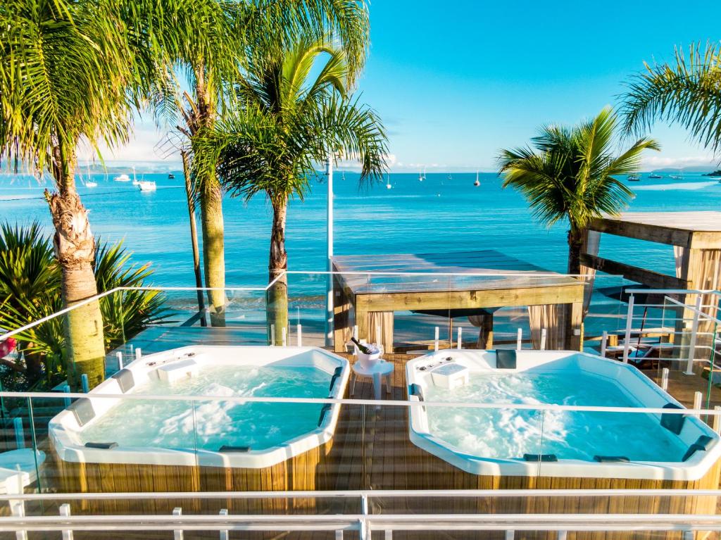 two hot tubs on a balcony overlooking the ocean at Pousada dos Sonhos in Florianópolis