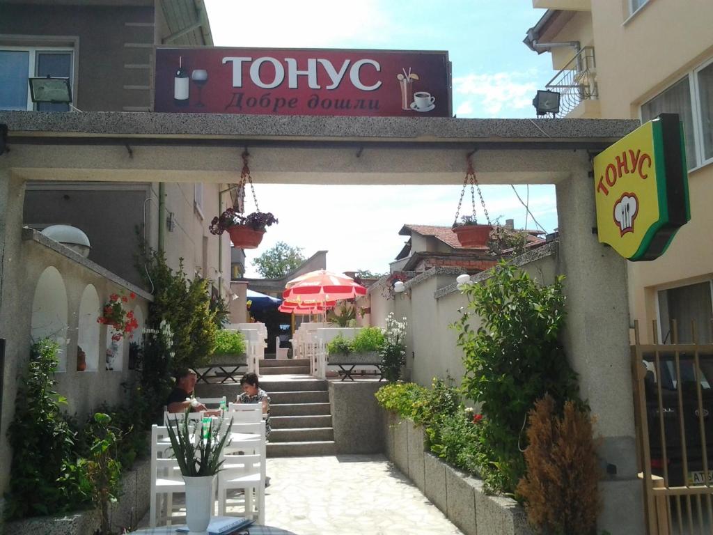 un restaurant avec des personnes assises à l'extérieur d'un bâtiment dans l'établissement Tonus Guest House, à Obzor
