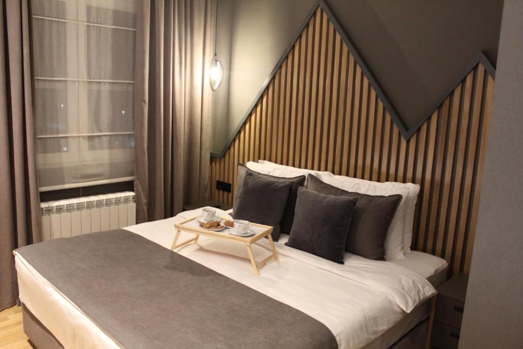 a bedroom with a large bed with a table on it at Modern mountain - Crown apartment in Kolašin