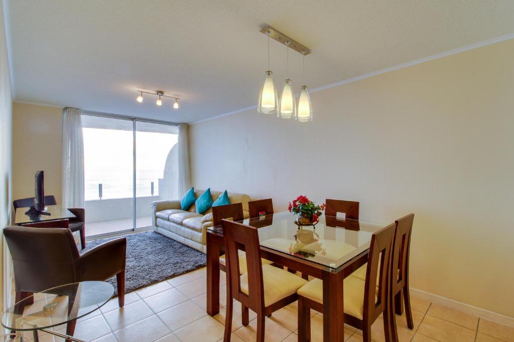 uma sala de jantar e sala de estar com mesa e cadeiras em Oceanic relájate cerca de todo em La Serena