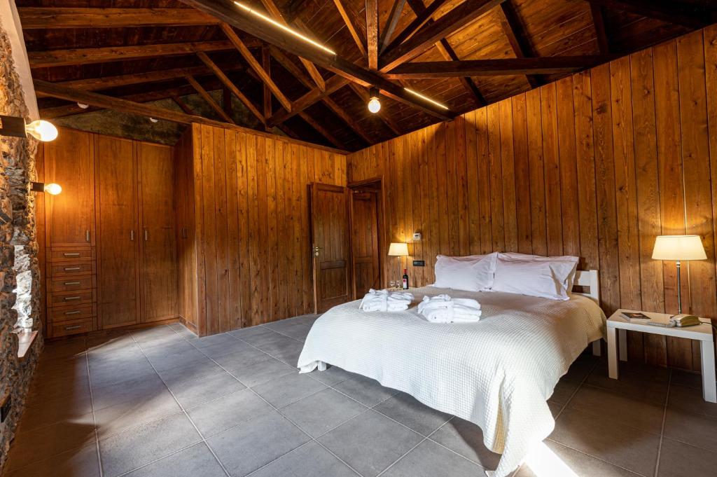 a bedroom with a large bed with wooden walls at Anastasia House in Nimfasía
