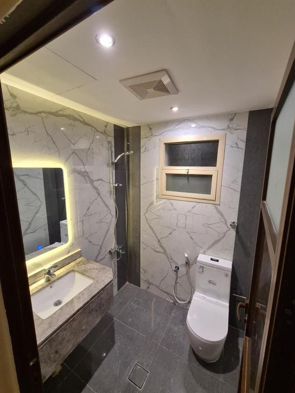 a bathroom with a sink and a toilet and a mirror at Rose Neri Lavender روز نيري الخزامى in Al Khobar